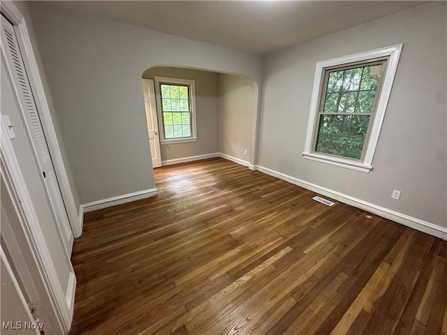 13707 Drexmore Rd, Shaker Heights, OH 44120 - empty room with arched walkways, dark wood finished floors, and baseboards