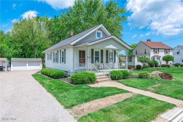 163 E Martin St, Amherst, OH 44001 - view of front of home with a porch, an outdoor structure, a garage, a front yard, and a chimney