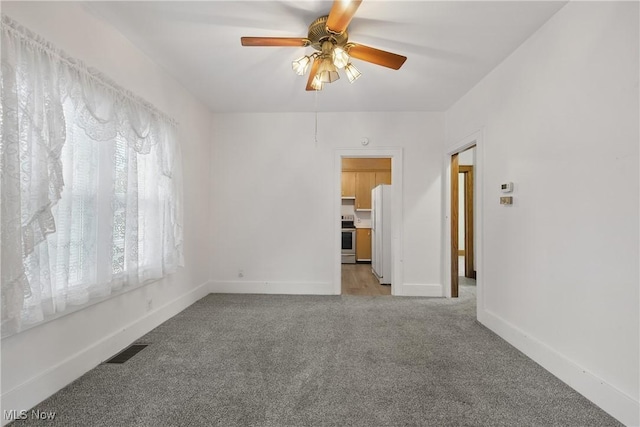 163 E Martin St, Amherst, OH 44001 - spare room featuring light colored carpet, ceiling fan, and baseboards
