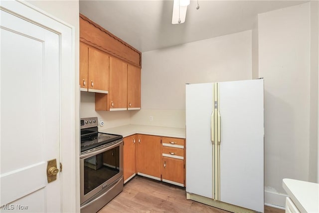 163 E Martin St, Amherst, OH 44001 - kitchen with freestanding refrigerator, stainless steel range with electric cooktop, light wood-type flooring, and light countertops