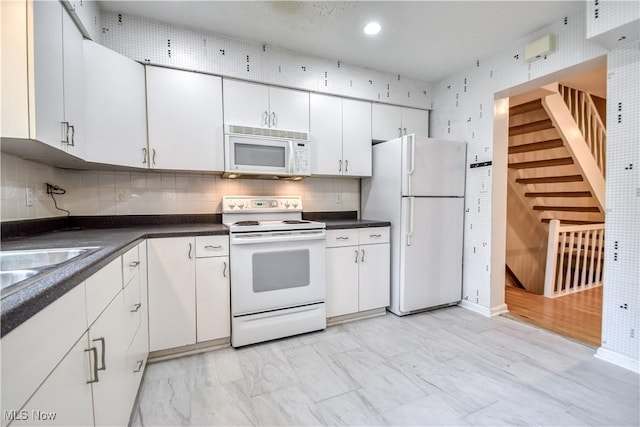 4473 Habersham Ln S, Richmond Heights, OH 44143 - kitchen with white appliances, dark countertops, white cabinets, backsplash, and light marble finish floors