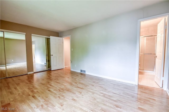 4473 Habersham Ln S, Richmond Heights, OH 44143 - unfurnished bedroom with multiple closets, light wood finished floors, connected bathroom, and baseboards
