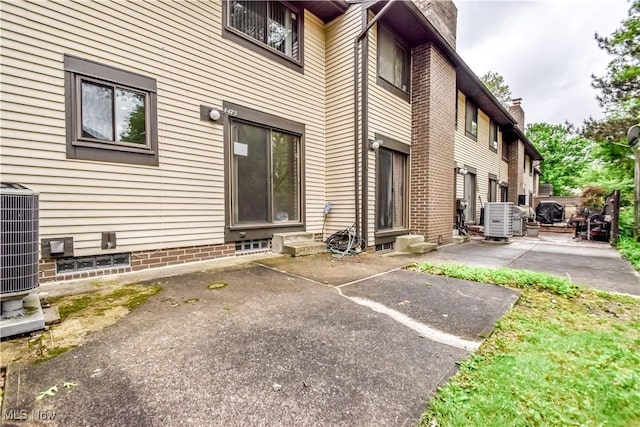 4473 Habersham Ln S, Richmond Heights, OH 44143 - view of exterior entry with cooling unit, a patio, and a chimney
