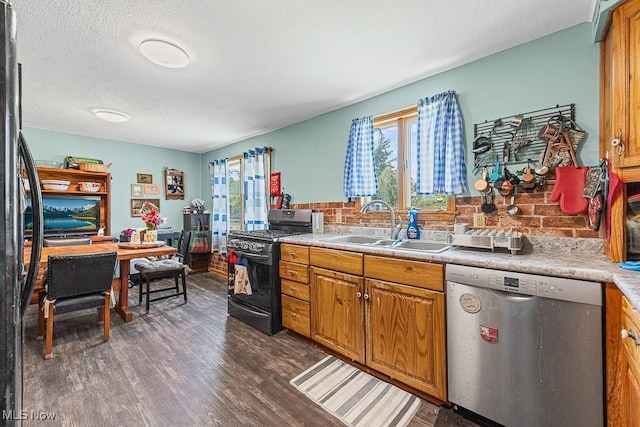 5869 Beechwood Ave, Alliance, OH 44601 - kitchen with dishwasher, black gas stove, a sink, healthy amount of natural light, and a textured ceiling