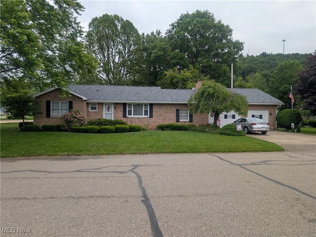 115 SW Spring St, Gnadenhutten, OH 44629 - ranch-style house featuring concrete driveway, a front lawn, brick siding, and a garage