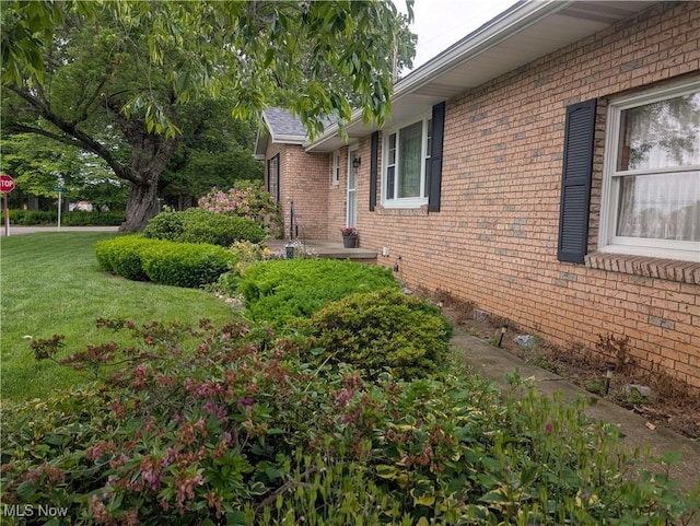 115 SW Spring St, Gnadenhutten, OH 44629 - view of property exterior featuring brick siding and a yard