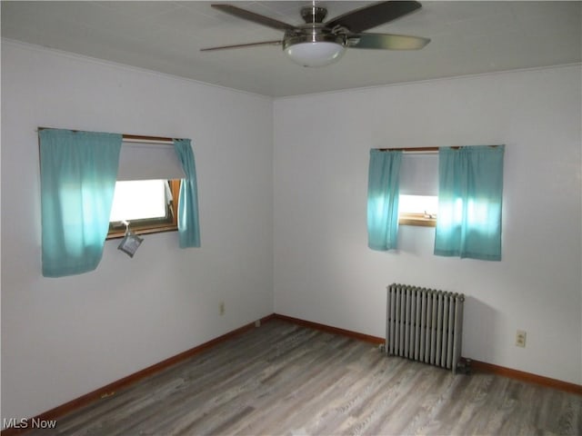 163 N Chestnut St, Linesville, PA 16424 - unfurnished room with radiator heating unit, ceiling fan, wood finished floors, baseboards, and crown molding