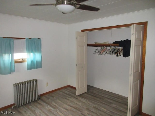 163 N Chestnut St, Linesville, PA 16424 - unfurnished bedroom featuring radiator heating unit, wood finished floors, a ceiling fan, and a closet