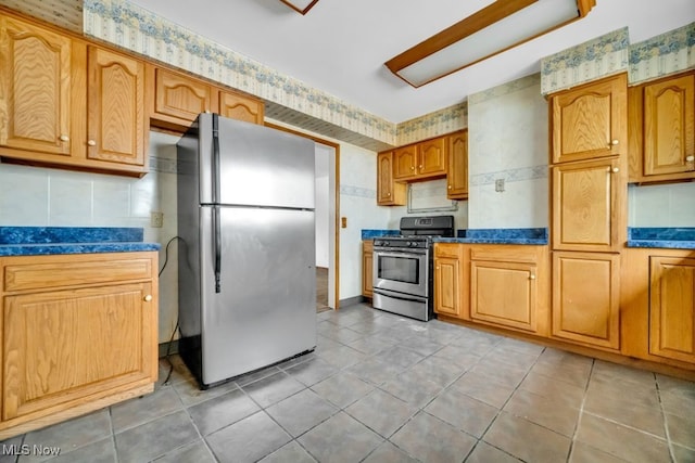 1586 E 86th St, Cleveland, OH 44106 - kitchen with stainless steel appliances, dark countertops, light tile patterned floors, and brown cabinetry