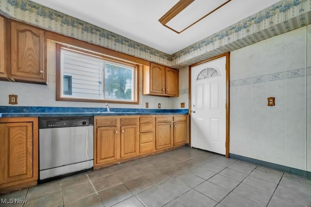 1586 E 86th St, Cleveland, OH 44106 - kitchen featuring dishwasher, brown cabinets, dark countertops, and light tile patterned floors