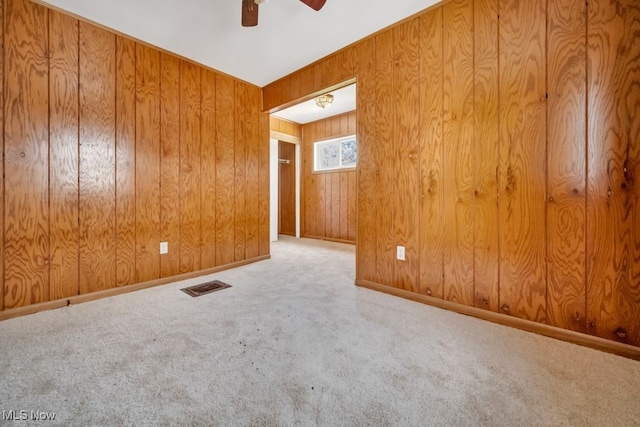 1586 E 86th St, Cleveland, OH 44106 - empty room featuring a ceiling fan, carpet floors, and wood walls
