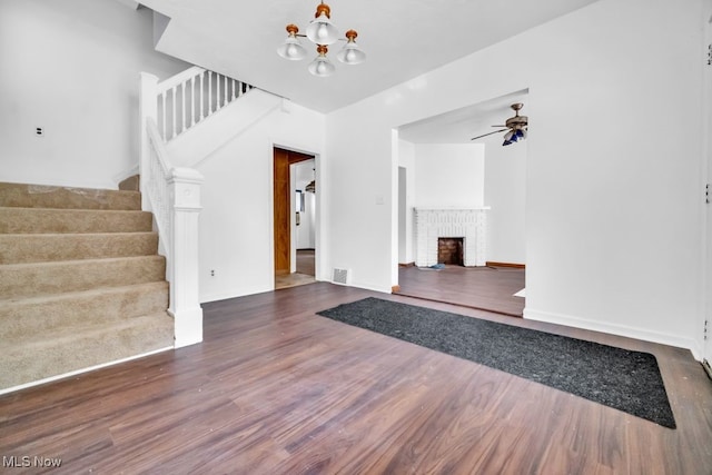 1586 E 86th St, Cleveland, OH 44106 - unfurnished living room with stairway, wood finished floors, ceiling fan, and a fireplace