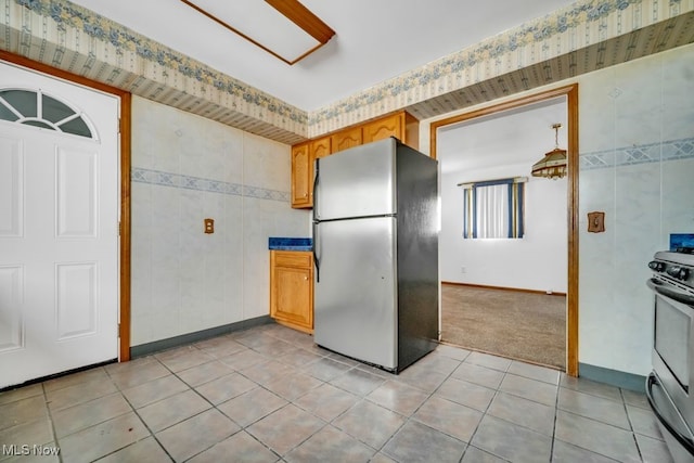 1586 E 86th St, Cleveland, OH 44106 - kitchen featuring appliances with stainless steel finishes, baseboards, light tile patterned floors, light carpet, and dark countertops