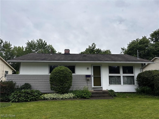 2325 Stewart Dr NW, Warren, OH 44485 - view of front of house with a chimney and a front lawn