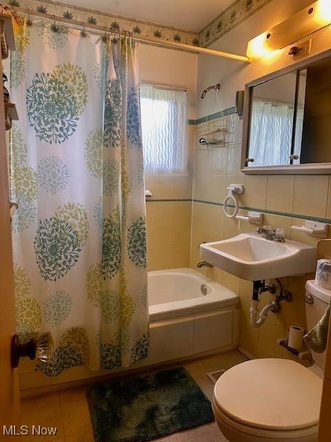 4179 Riverside Dr, Youngstown, OH 44511 - bathroom featuring tile patterned flooring, tile walls, shower / bath combo with shower curtain, toilet, and a sink