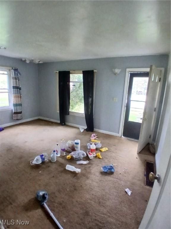 702 Hall St NW, Warren, OH 44483 - unfurnished living room featuring carpet, healthy amount of natural light, and baseboards