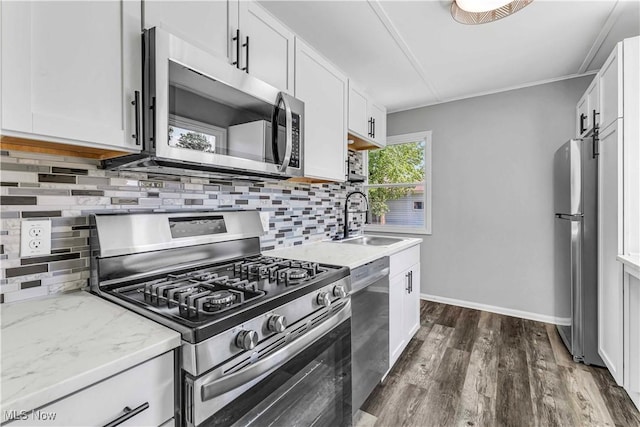 576 Franklin Ave, Barberton, OH 44203 - kitchen featuring appliances with stainless steel finishes, a sink, decorative backsplash, dark wood-style flooring, and white cabinets