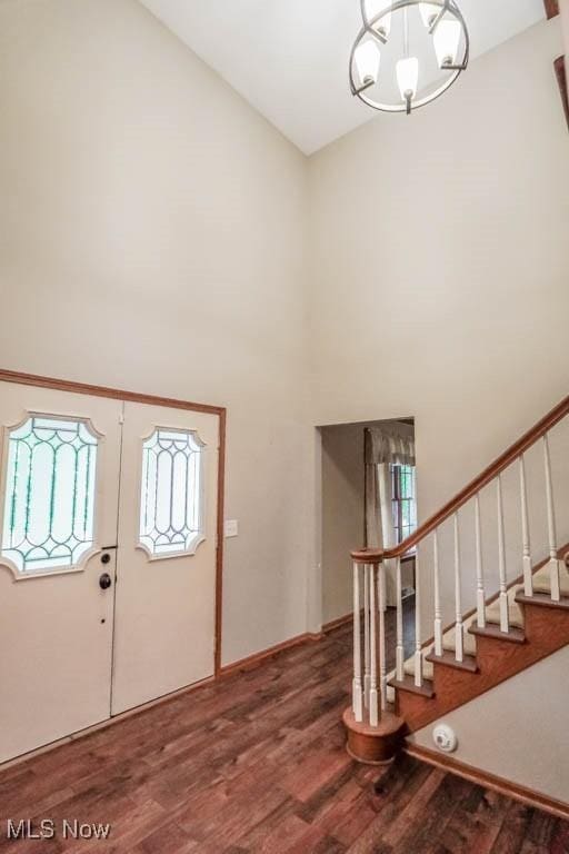2410 Rohrer St NW, North Canton, OH 44720 - foyer entrance featuring wood finished floors, a high ceiling, stairs, a chandelier, and baseboards