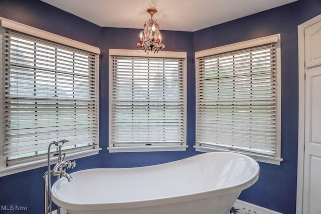 2410 Rohrer St NW, North Canton, OH 44720 - bathroom with a soaking tub, a chandelier, and baseboards