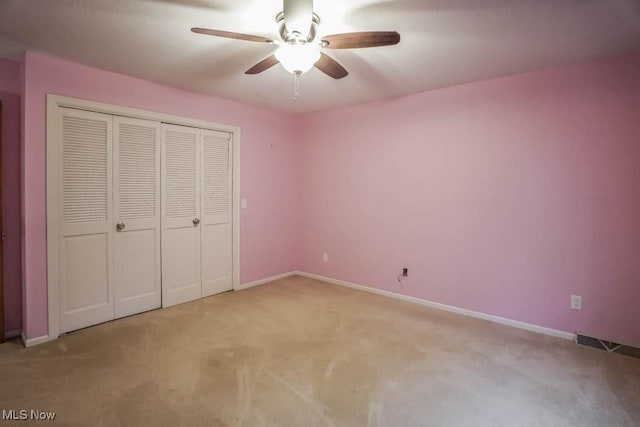 2410 Rohrer St NW, North Canton, OH 44720 - unfurnished bedroom featuring carpet flooring, baseboards, a closet, and a ceiling fan