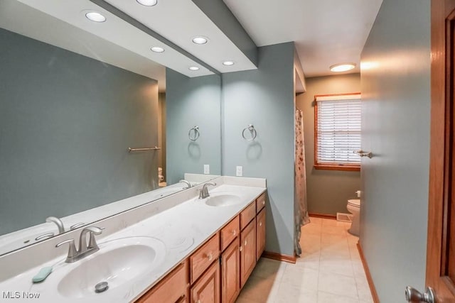 2410 Rohrer St NW, North Canton, OH 44720 - bathroom featuring toilet, double vanity, recessed lighting, tile patterned floors, and baseboards