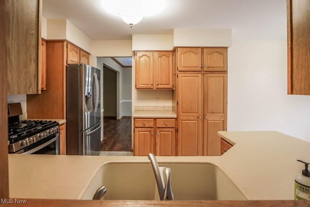 2410 Rohrer St NW, North Canton, OH 44720 - kitchen with stainless steel appliances, light countertops, a sink, and dark wood-type flooring