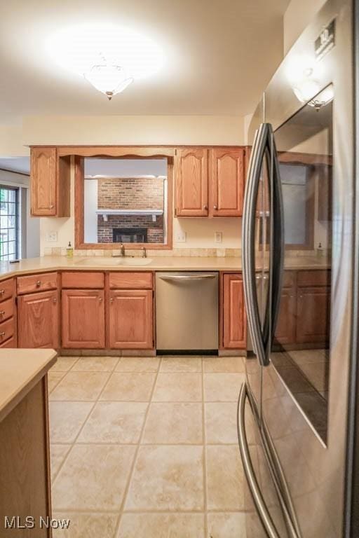 2410 Rohrer St NW, North Canton, OH 44720 - kitchen featuring stainless steel appliances, light countertops, light tile patterned flooring, and a sink