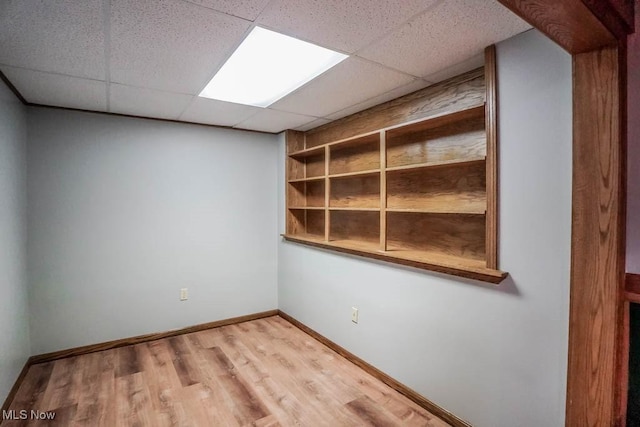 2410 Rohrer St NW, North Canton, OH 44720 - unfurnished room with wood finished floors, a drop ceiling, and baseboards