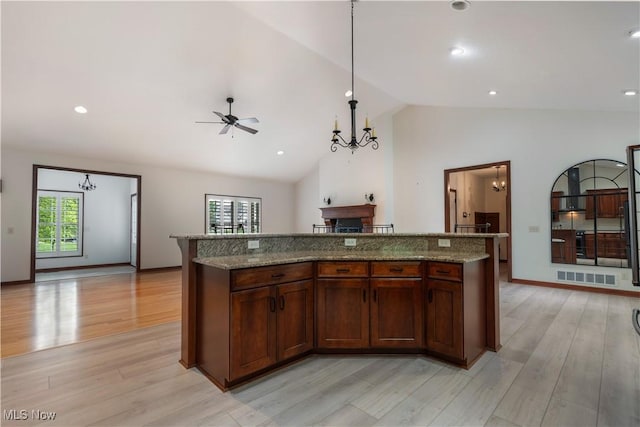 4953 Maclaren Ave NW, Massillon, OH 44646 - kitchen with a kitchen island, a chandelier, stone countertops, light wood-type flooring, and high vaulted ceiling