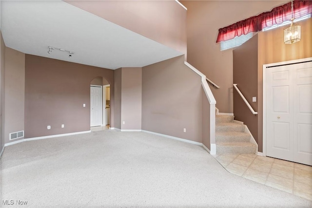 7284 Forest Cove Ln, Northfield, OH 44067 - entrance foyer with arched walkways, carpet floors, stairway, rail lighting, and baseboards