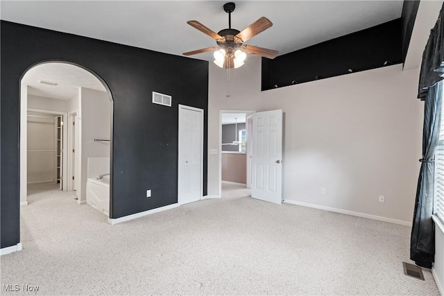 7284 Forest Cove Ln, Northfield, OH 44067 - unfurnished bedroom featuring arched walkways, carpet, baseboards, a high ceiling, and a closet