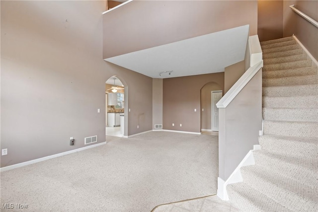 7284 Forest Cove Ln, Northfield, OH 44067 - staircase with arched walkways, carpet floors, baseboards, and ceiling fan