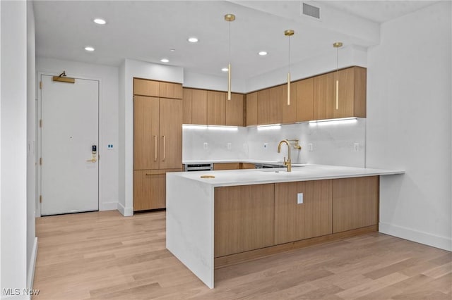 629 Euclid Ave Unit 1510, Cleveland, OH 44114 - kitchen with a sink, a peninsula, light countertops, light wood finished floors, and baseboards