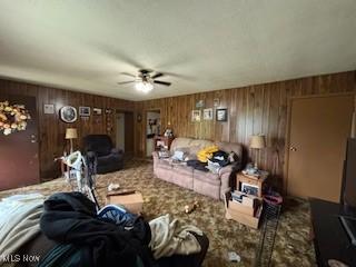 5806 Risher Rd, Leavittsburg, OH 44430 - carpeted living area featuring ceiling fan and wooden walls