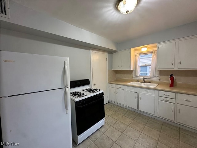 776 Triplett Blvd, Akron, OH 44306 - kitchen with freestanding refrigerator, range with gas cooktop, a sink, light countertops, and white cabinets