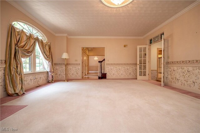 4219 Olde Charted Trl, Poland, OH 44514 - carpeted empty room featuring wallpapered walls, ornamental molding, stairs, french doors, and wainscoting