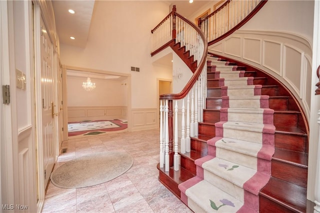4219 Olde Charted Trl, Poland, OH 44514 - staircase featuring a decorative wall, a chandelier, recessed lighting, a high ceiling, and wainscoting