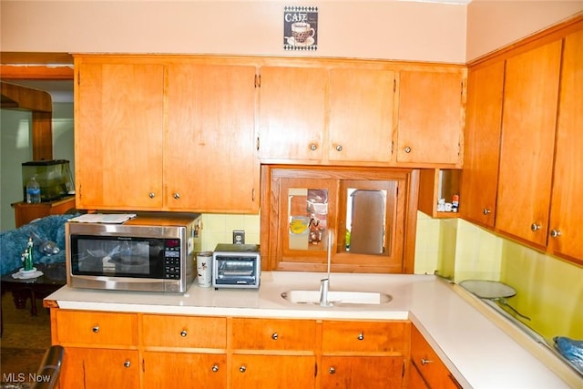 122 21st St NW, Barberton, OH 44203 - kitchen featuring stainless steel microwave, light countertops, and brown cabinetry