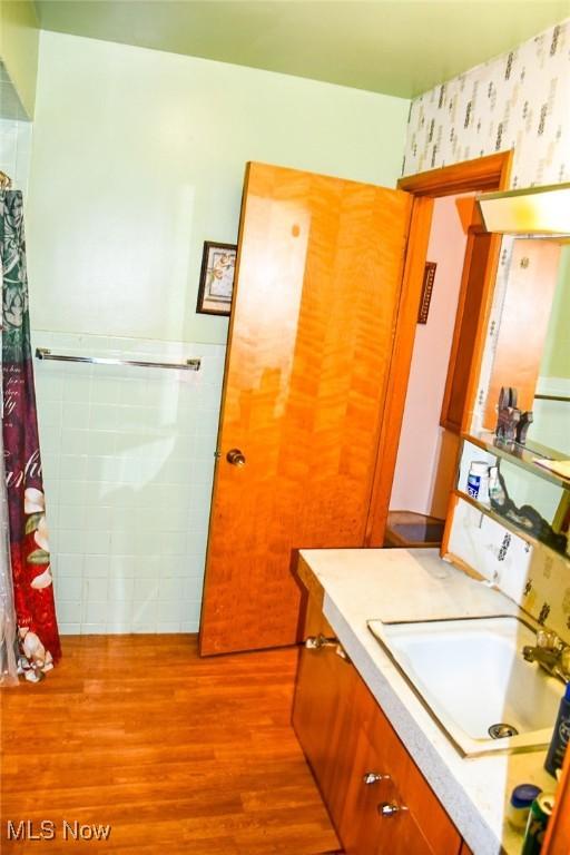 122 21st St NW, Barberton, OH 44203 - full bathroom with wood finished floors, vanity, wallpapered walls, and a shower with curtain