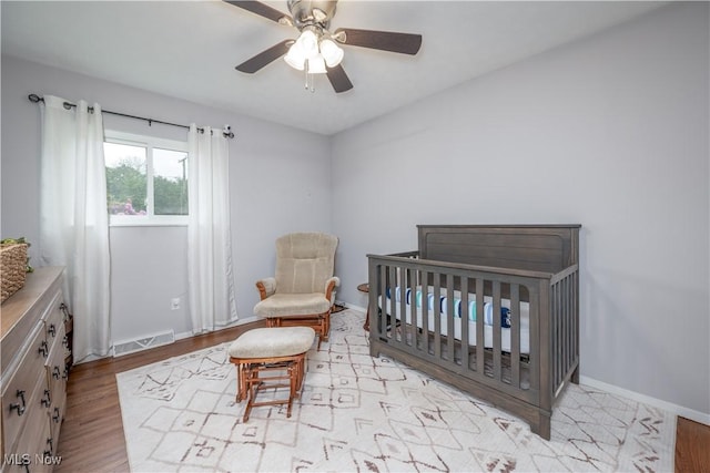 488 Spaulding Dr, Kent, OH 44240 - bedroom with light wood finished floors, a crib, baseboards, and a ceiling fan