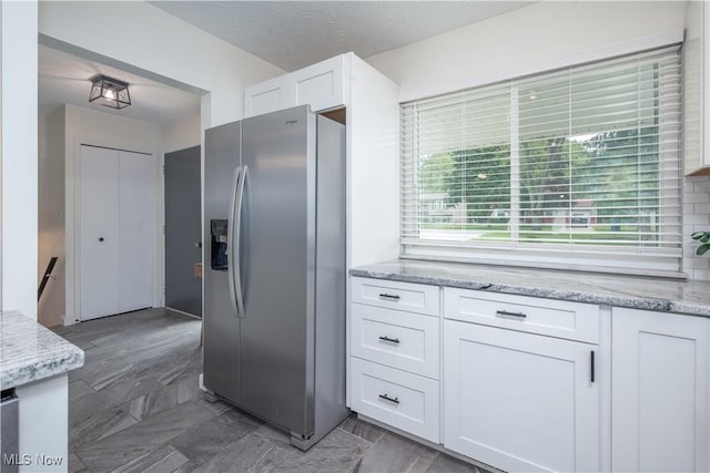488 Spaulding Dr, Kent, OH 44240 - kitchen with stainless steel refrigerator with ice dispenser, white cabinets, light stone countertops, and a textured ceiling