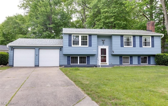 4285 Baird Rd, Stow, OH 44224 - raised ranch featuring an attached garage, driveway, a front lawn, a chimney, and a shingled roof