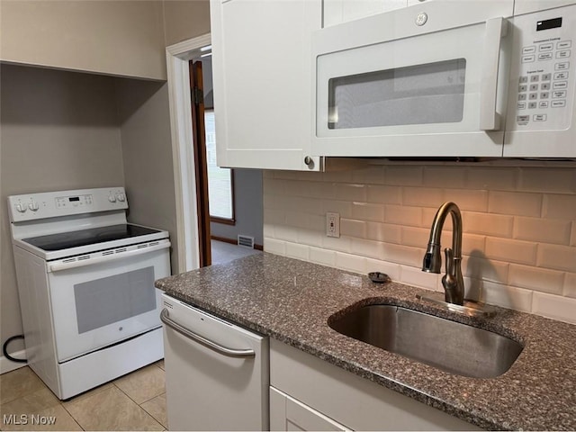 22561 Chardon Rd, Euclid, OH 44117 - kitchen with white appliances, a sink, dark stone countertops, white cabinetry, and backsplash