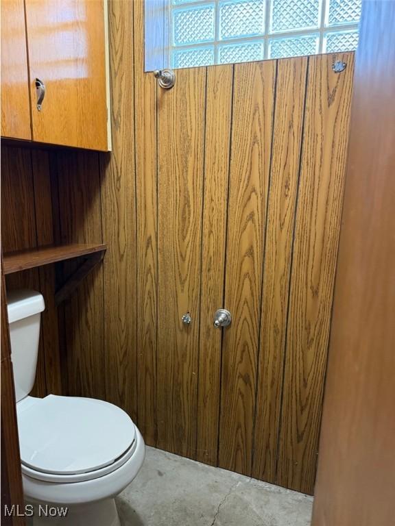 22561 Chardon Rd, Euclid, OH 44117 - bathroom with toilet, plenty of natural light, and wooden walls
