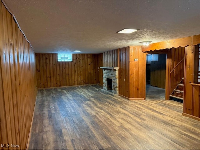 22561 Chardon Rd, Euclid, OH 44117 - basement featuring a textured ceiling, wood finished floors, stairway, a fireplace, and wooden walls