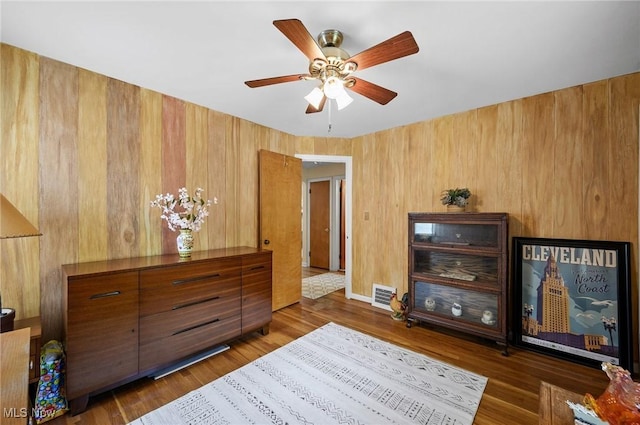 14300 Bidwell Ave, Cleveland, OH 44111 - bedroom with wood finished floors, wood walls, and ceiling fan