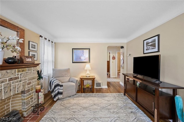 14300 Bidwell Ave, Cleveland, OH 44111 - living room with arched walkways, a fireplace, wood finished floors, and baseboards