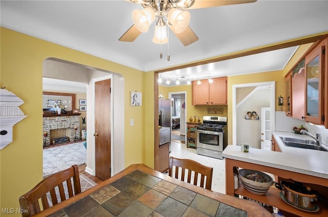 14300 Bidwell Ave, Cleveland, OH 44111 - kitchen with gas range, a sink, a ceiling fan, light countertops, and rail lighting