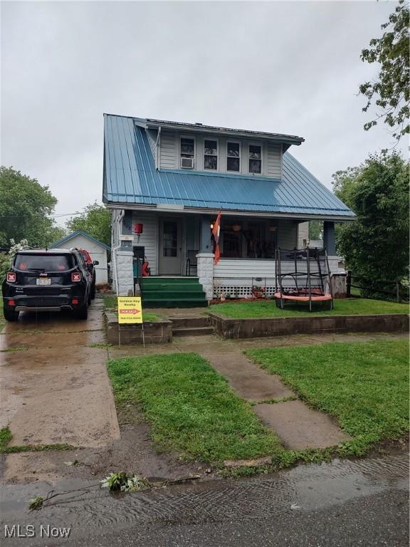 1028 Kenilworth Ave, Coshocton, OH 43812 - view of front facade with covered porch, metal roof, and a front lawn