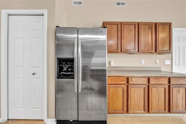 2716 Edgebrook Xing, Twinsburg, OH 44087 - kitchen with stainless steel refrigerator with ice dispenser, brown cabinetry, light countertops, and light wood-style flooring